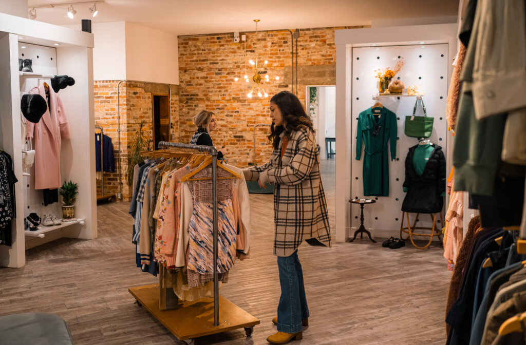 A shopper browses clothing racks at the Peacock Boutique Consignment.