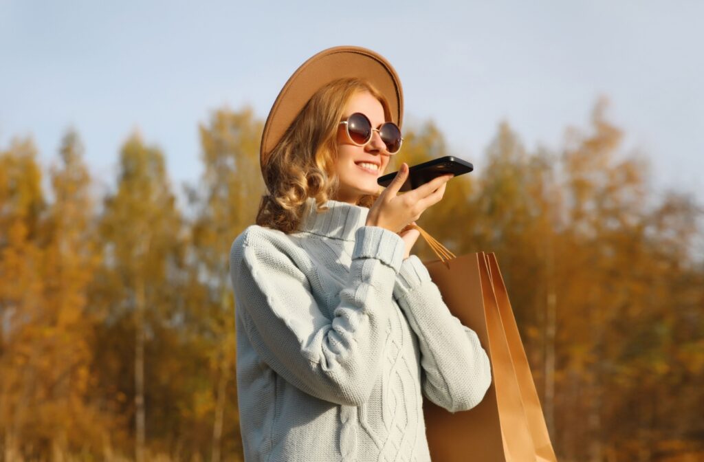 A person holding a phone and a shopping bag wearing a soft knit turtleneck sweater.