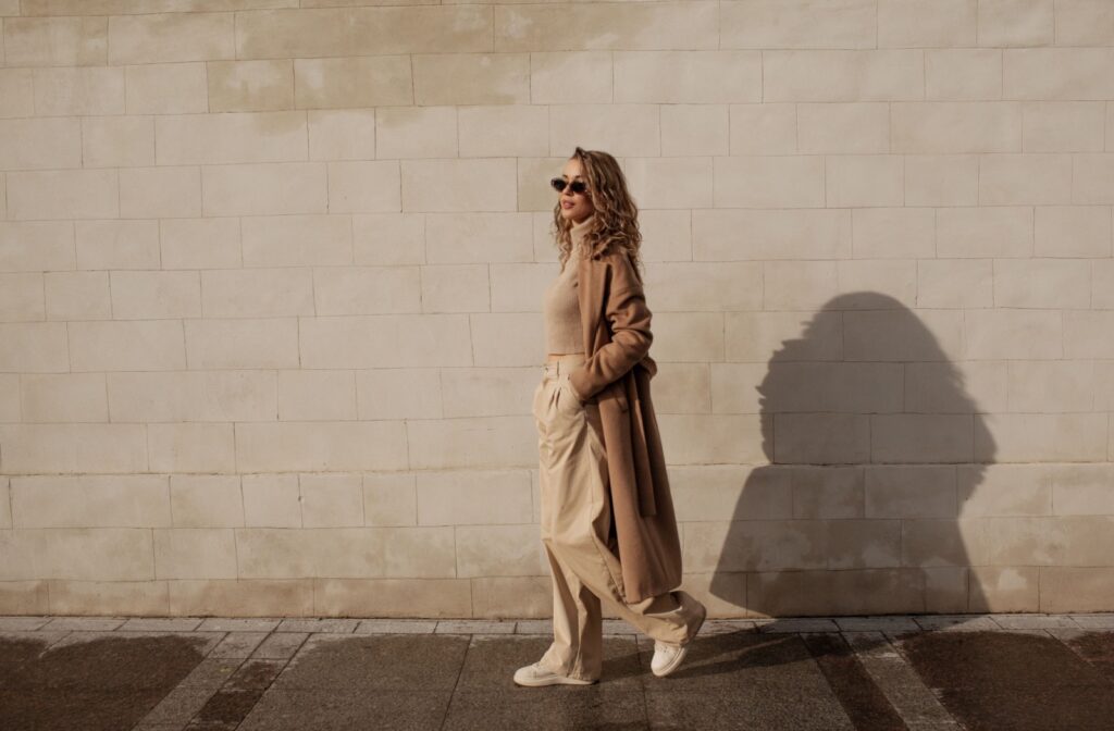 Stylish person standing in front of a brick wall wearing a business-casual fall outfit